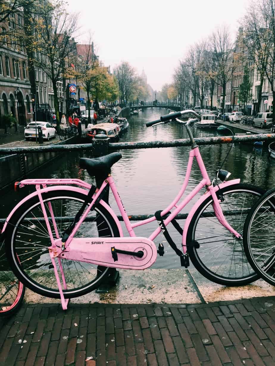 A pink bike in Amsterdam...pops of pink color line the bridges of Amsterdam's canals! The cheapest hotel for an instagram- and eco-friendly stay in Amsterdam: Ecomama Hotel Amsterdam is cozy, sustainable and made my time in Amsterdam special.