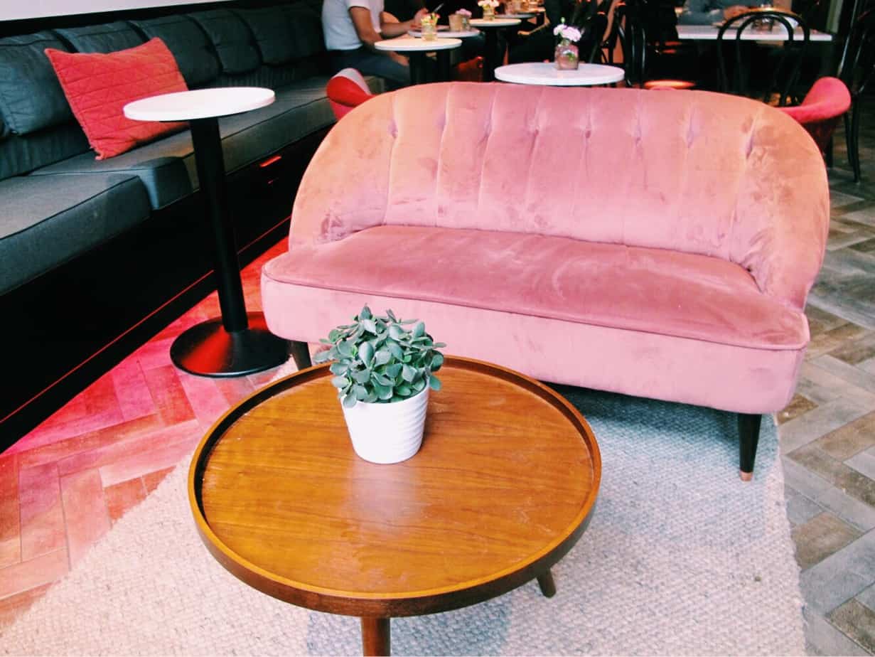 Pink velvet sofa at The Fix, the cafe at the entrance to Ecomama. The cheapest hotel for an instagram- and eco-friendly stay in Amsterdam: Ecomama Hotel Amsterdam is cozy, sustainable and made my time in Amsterdam special.