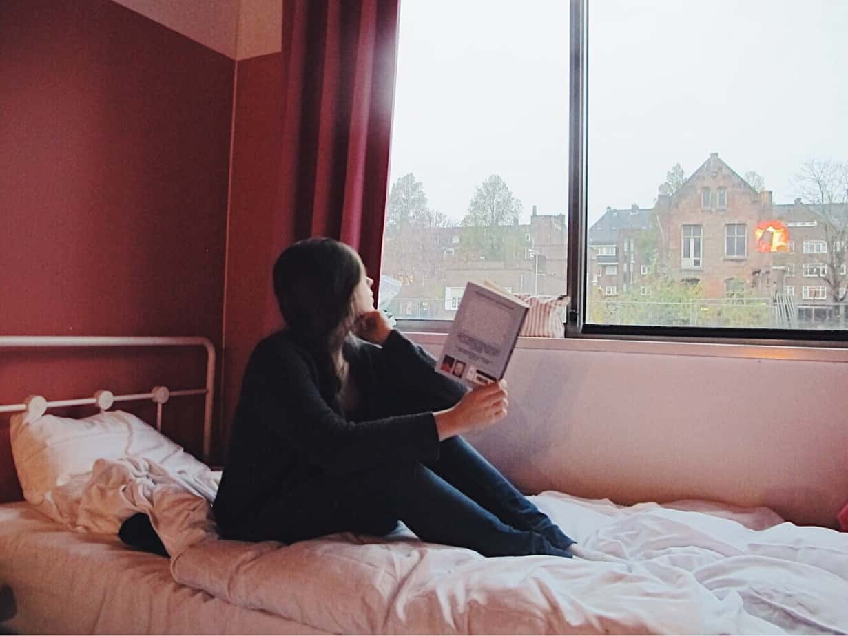 Enjoying my cozy and sustainable stay in Amsterdam with a good book in my all girls dorm room. The cheapest hotel for an instagram- and eco-friendly stay in Amsterdam: Ecomama Hotel Amsterdam is cozy, sustainable and made my time in Amsterdam special.