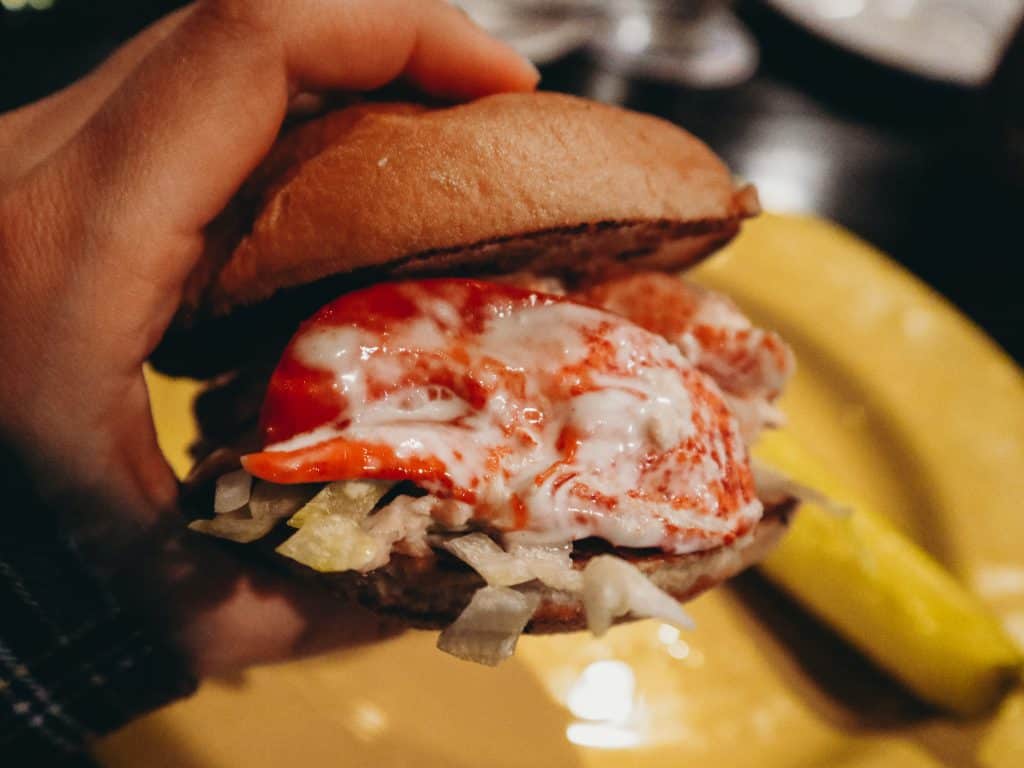 hand holding gluten free lobster roll.