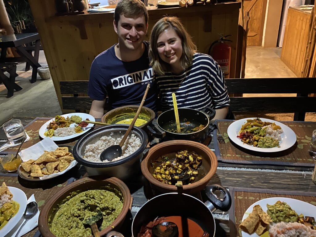 Dan and Sarah sitting in front of the curries they made in Sri Lanka