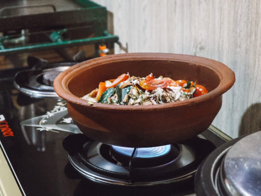 cooking class in Sri Lanka, a clay pot of curry cooking on a stove