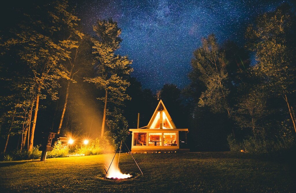 An A-frame Michigan cabin lit up under a starry night.