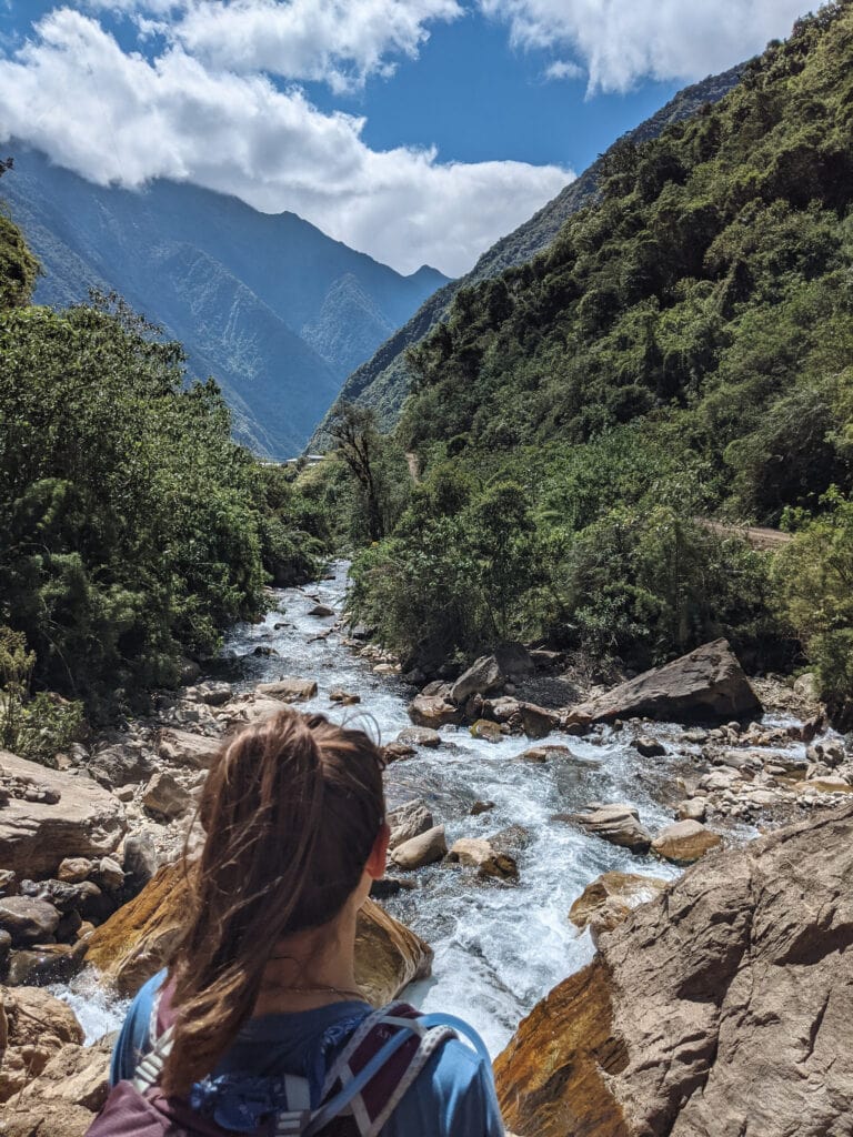Sarah standing at a river along the salkantay trail