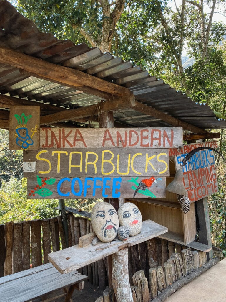 A red yellow and blue sign that says Inka Andean Starbucks Coffee along the salkantay trek to machu picchu