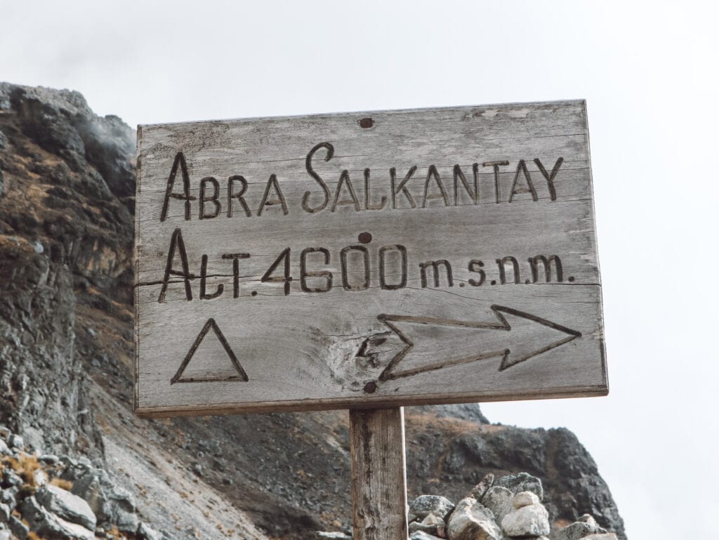 A sign that reads "Abra Salkantay Altitude 4600 meters" at Salkantay pass along the salkantay trek in Peru