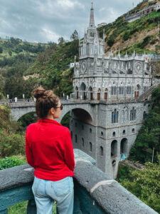 Sarah in pink jacket standing in front of the Las Lajas Sanctuary in Ipiales Colombia