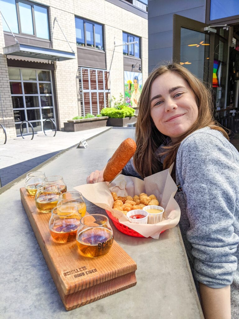 sarah with gluten free corn dog and cider flight at schilling cider in portland oregon