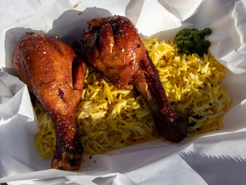 chicken and yellow rice in a white take out box