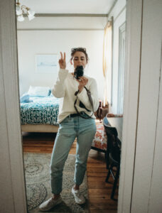 sarah giving the peace sign in a mirror in her hostel room