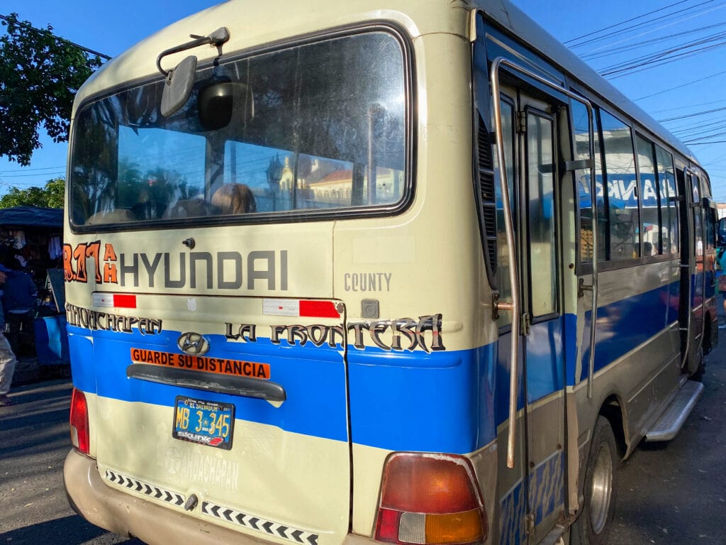 A white bus to the El Salvador to Guatemala border crossing at Las Chinimas