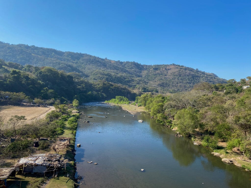 The rio paz - a wide river with green hills in the background.