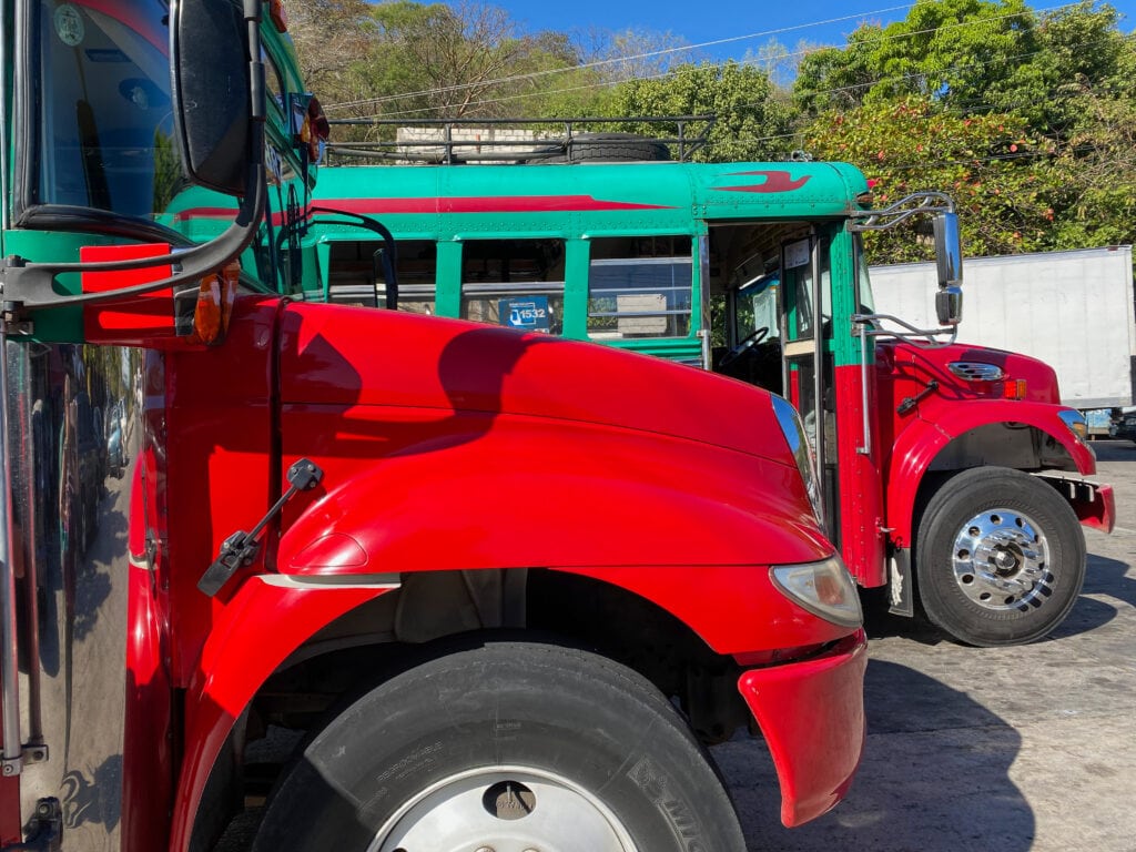 Red and green chicken buses (painted American school buses used in Central America).