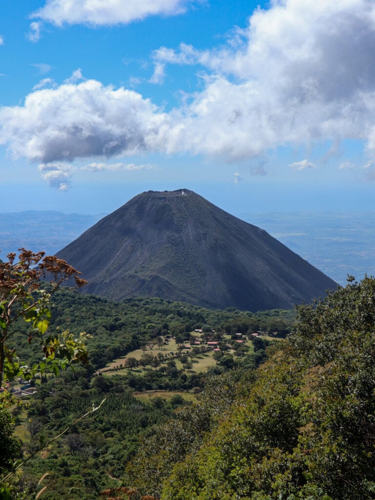 Izalco Volcano - a perfect conical shaped volcano with green forest in the foreground.