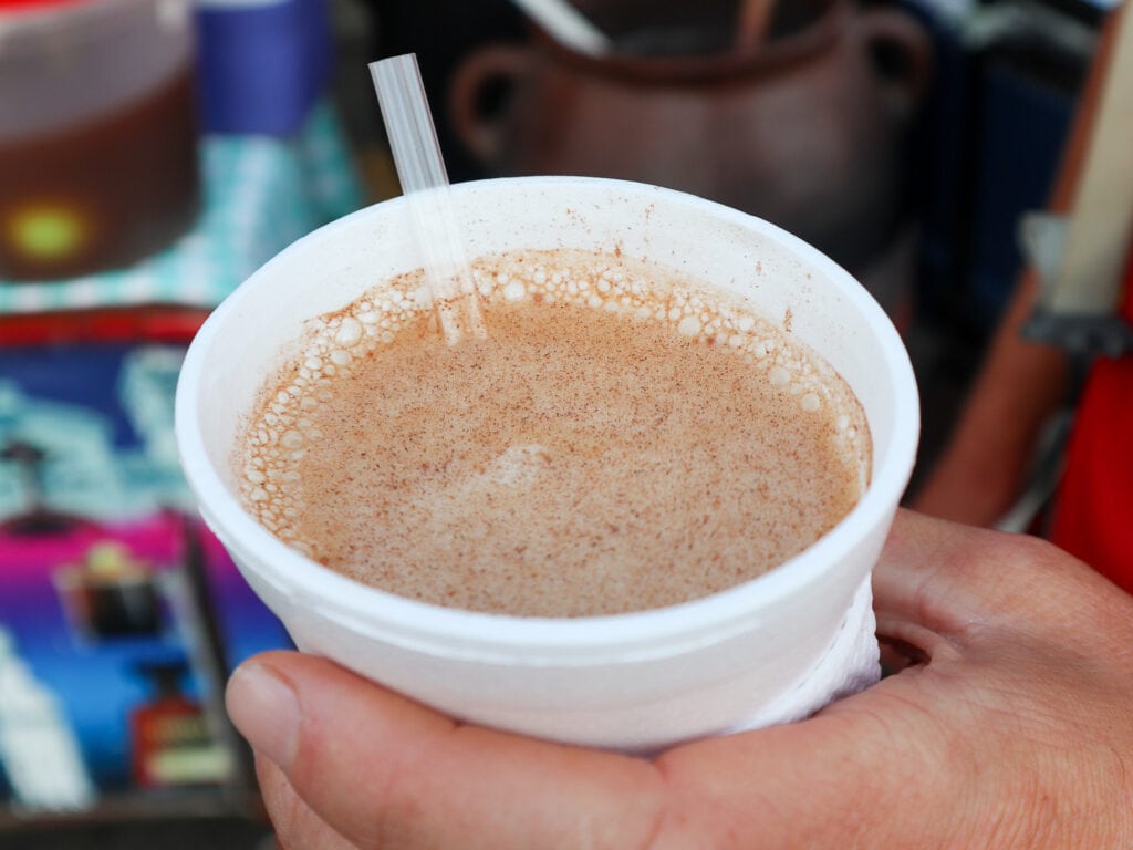 A white styrofoam cup with brown liquid inside.