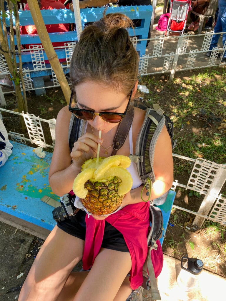 Sarah sipping out of a pineapple at the Juayua food festival.