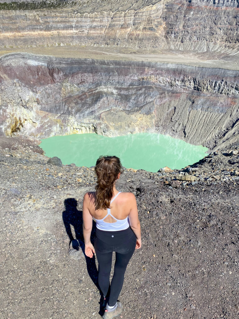 Sarah stands and looks out at crater lake.