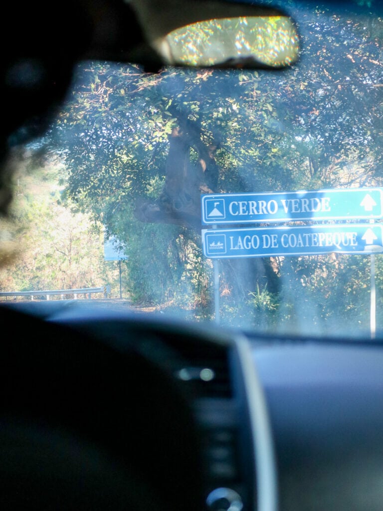 View out car windshield to road sign that says Cerro Verde
