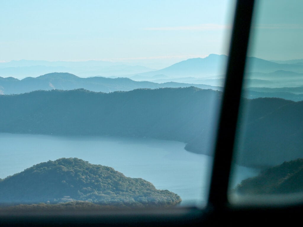 View of Coatepeque Lake with morning fog from a car window