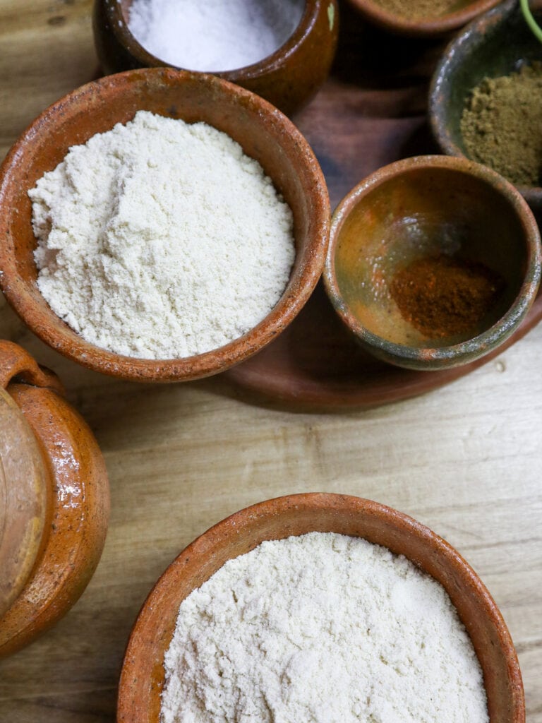 An aerial shot of clay bowls of corn flour and spices.