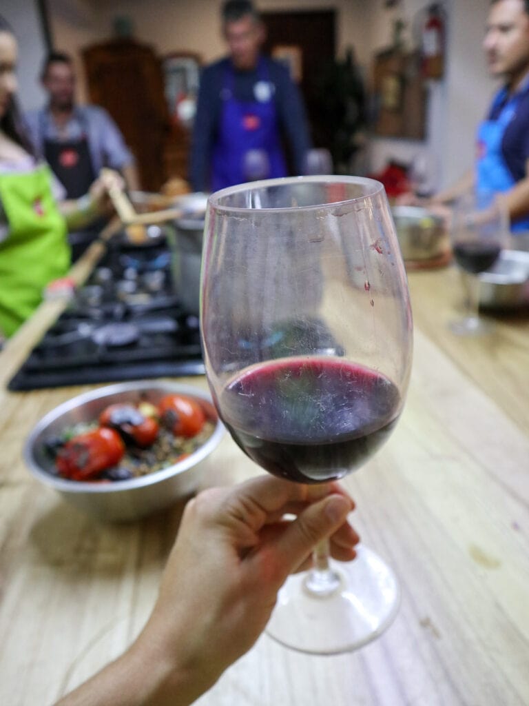 A glass of red wine with a kitchen in the background.