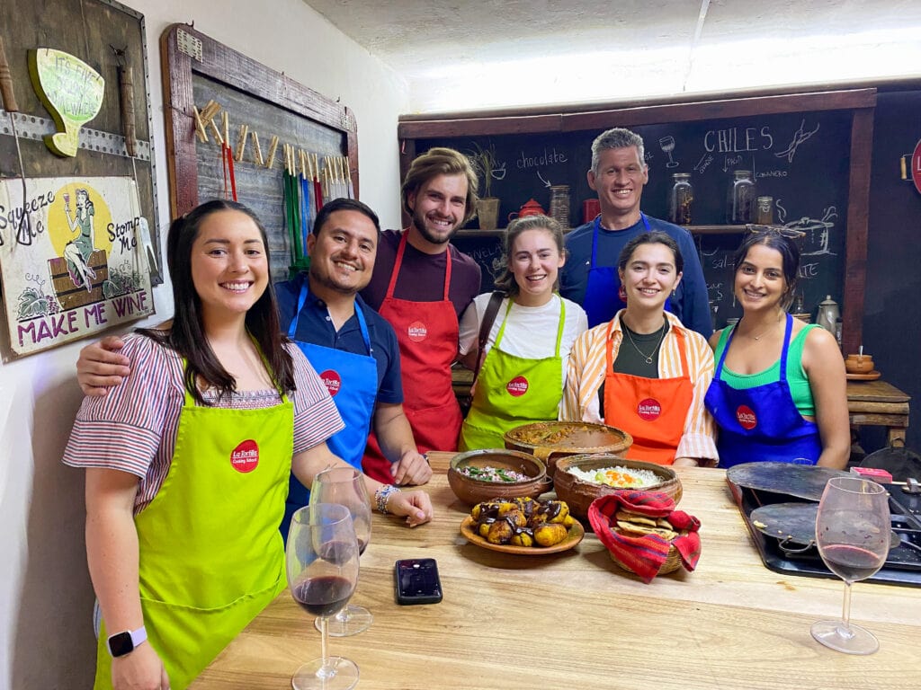 A group of people wearing bright aprons smiling for the camera.