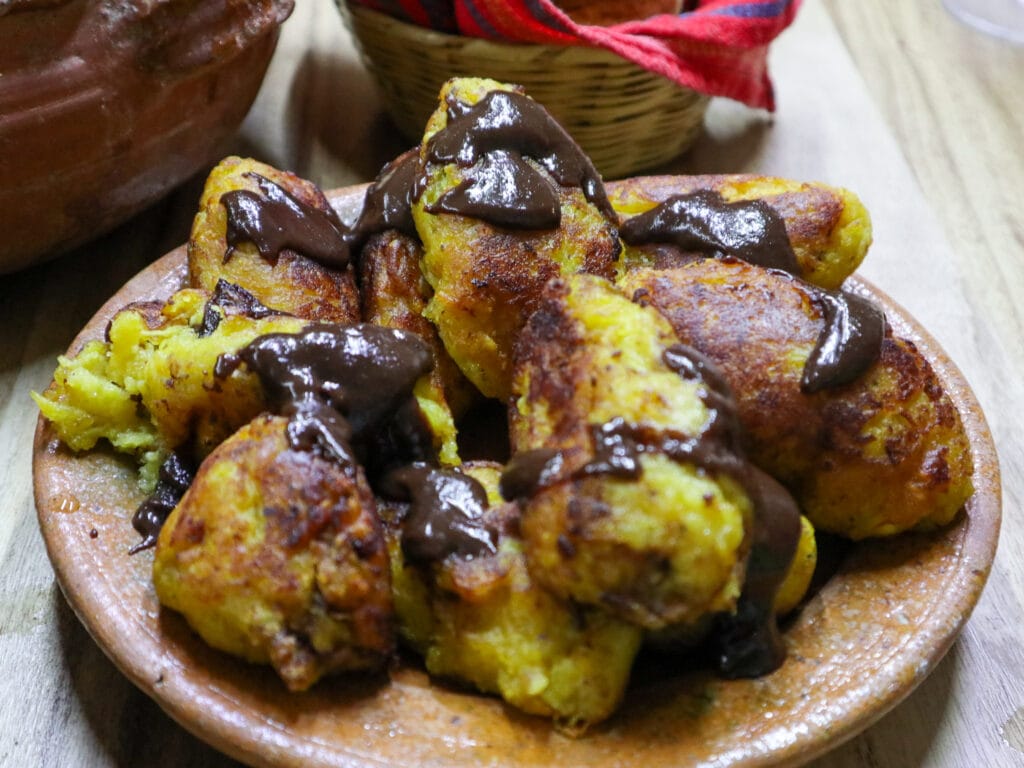 A clay plate of rellenitos de platano, a Guatemalan dessert.