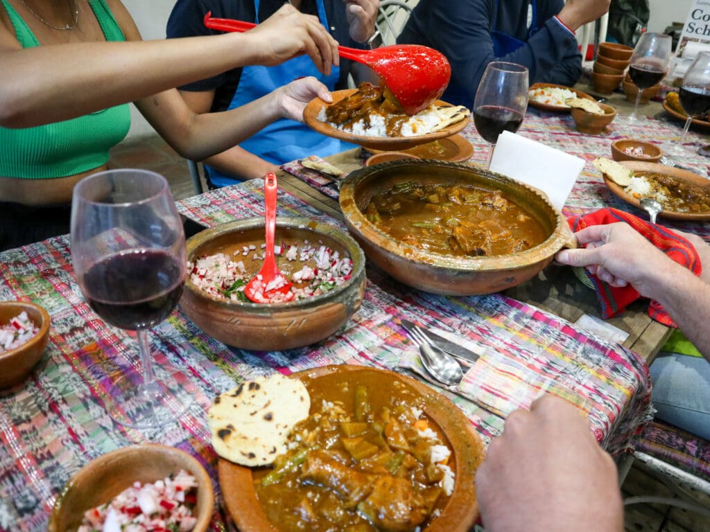 A colorful tablecloth with lots of clay dishes of Guatemalan foods.