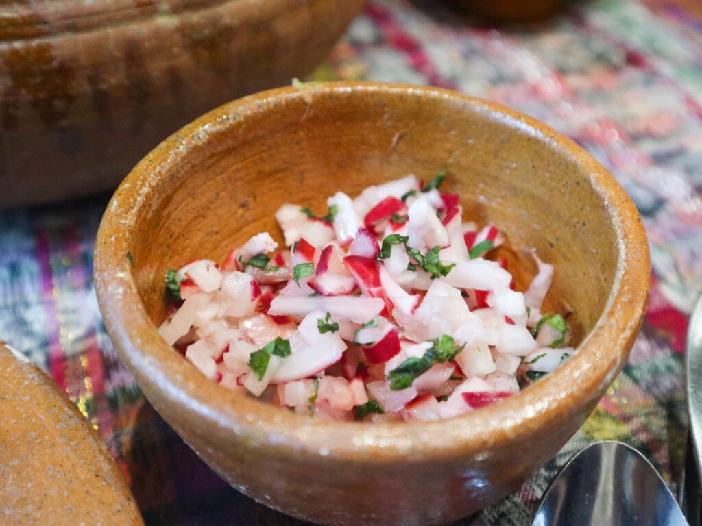 A clay bowl of finely chopped radish salad.