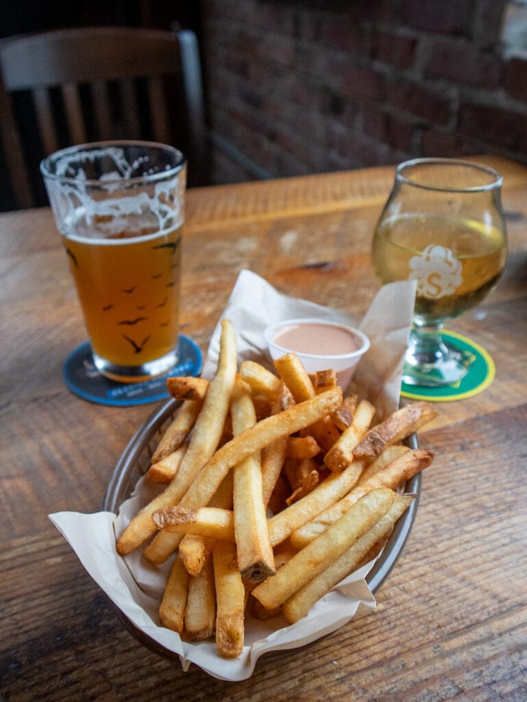 Gluten free french fries with two glasses of beer and cider in the background