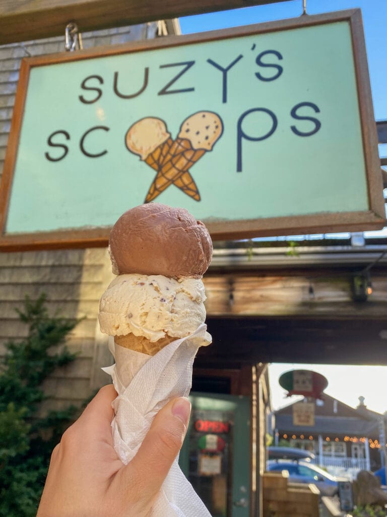 Double scoop ice cream in a gluten free cone with Suzy's Scoops sign in the background