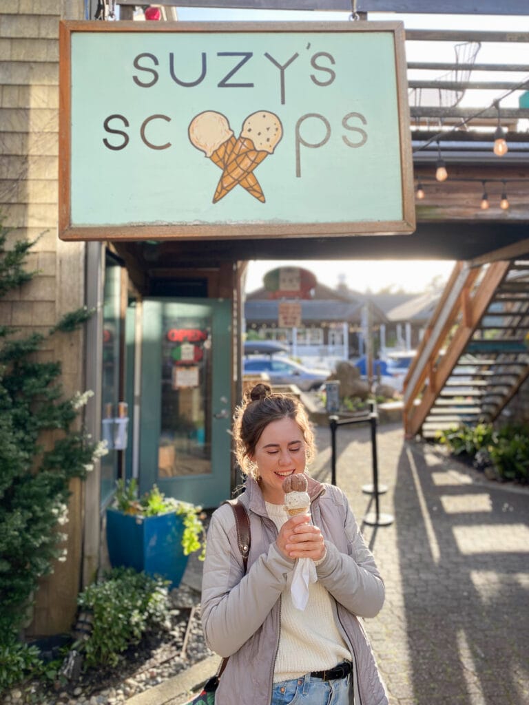 Sarah with her gluten free ice cream smiling in front of sign that says Suzy's Scoops