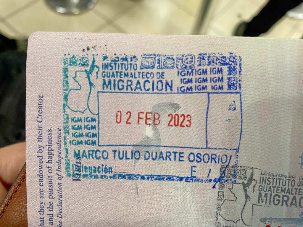 A blue and red guatemala exit stamp in a passport.