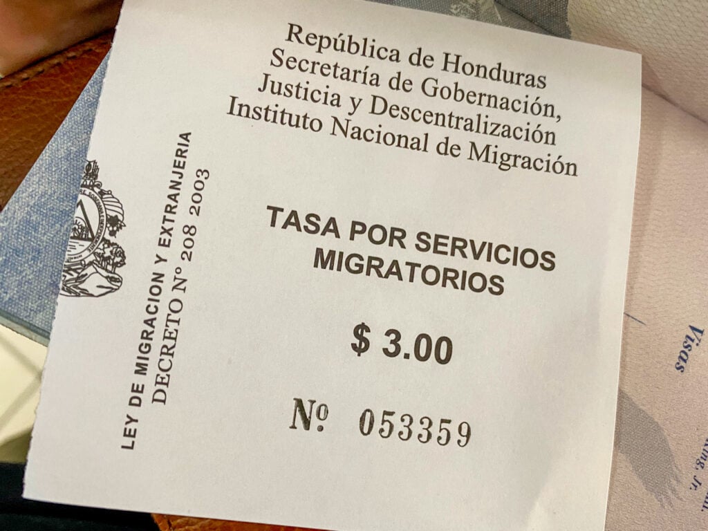 A receipt that says "tasa por servicios migratorios $3".