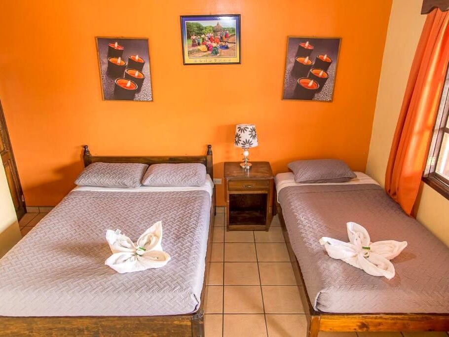 An orange room with two beds.