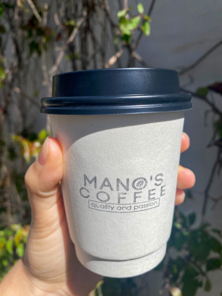 A white to-go cup that says Man's Coffee quality and passion on it.