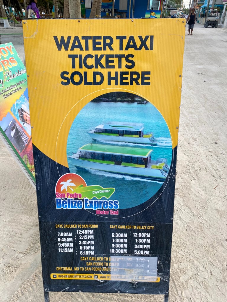 A sign that says water taxi tickets sold here, san pedro belize express water taxi and a timetable.