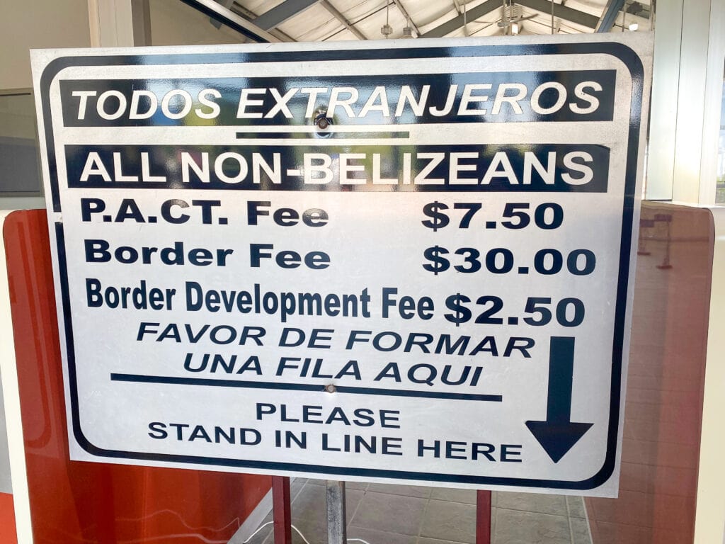 A sign that displays Belize exit taxes at the Belize to Mexico border crossing.