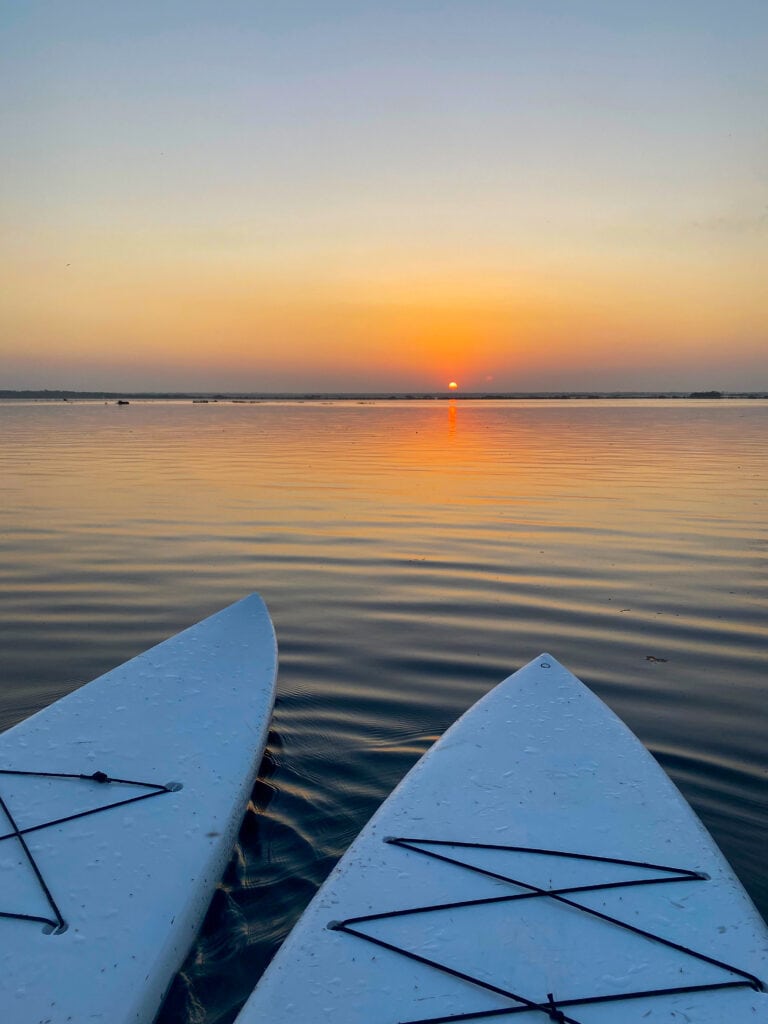 Two paddleboards in Bacalar Lake at sunrise.