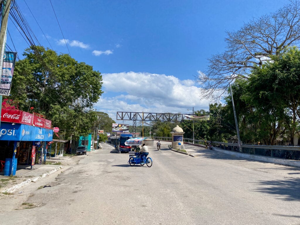 A sunny street with two bridges in the distance.