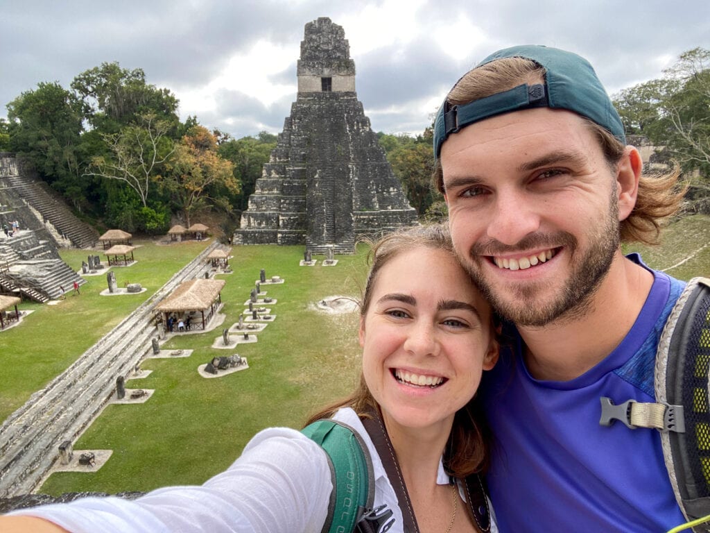 Selfie of Sarah and Dan smiling in front of Tikal Ruins in Guatemala.