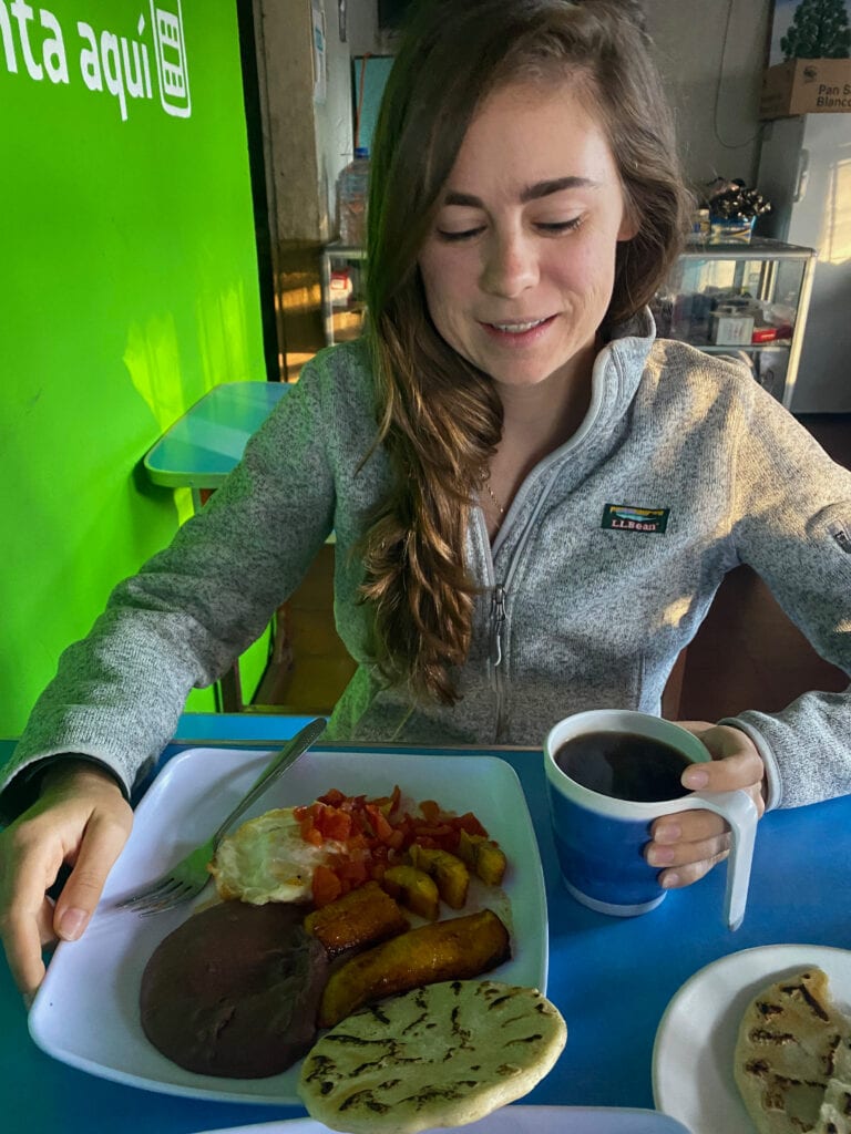 Sarah smiles and looks down at her breakfast.