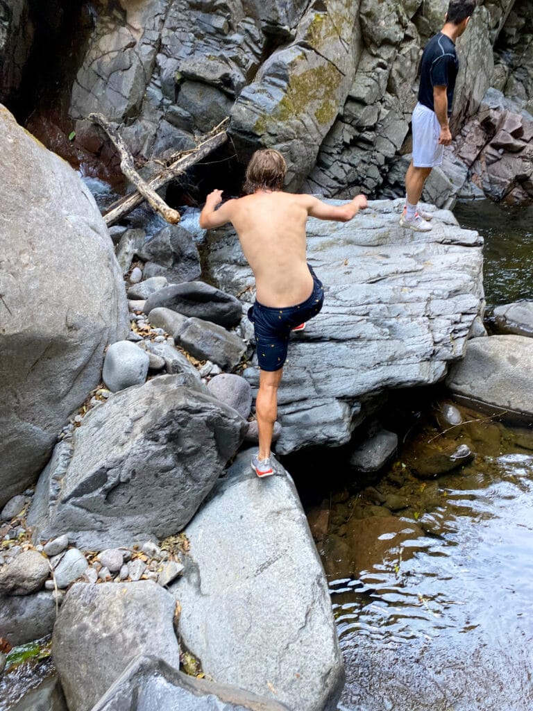 Dan jumps from one boulder to another.