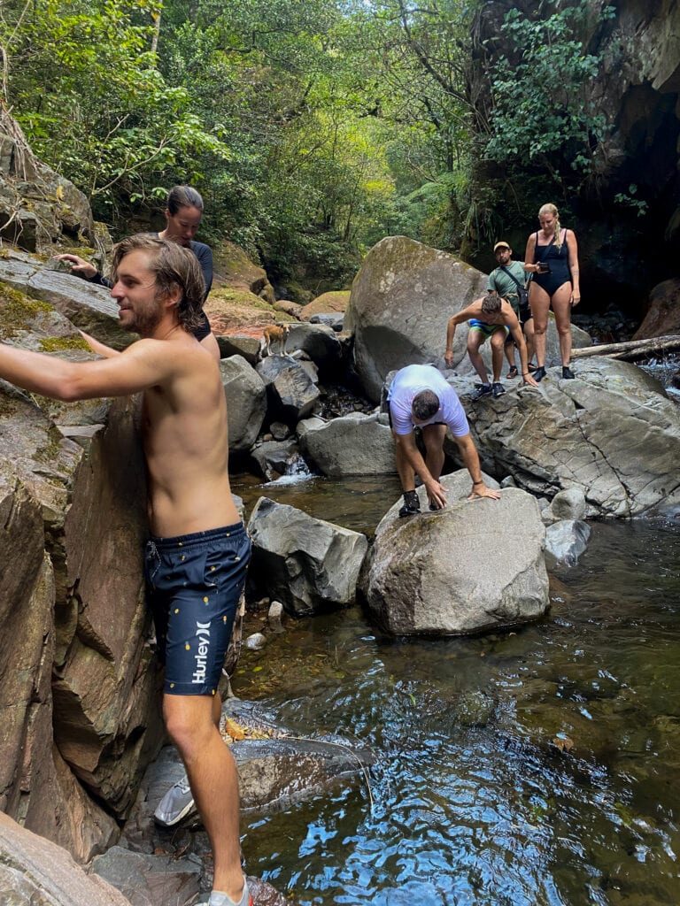 Dan climbs on the rocks next to a river.