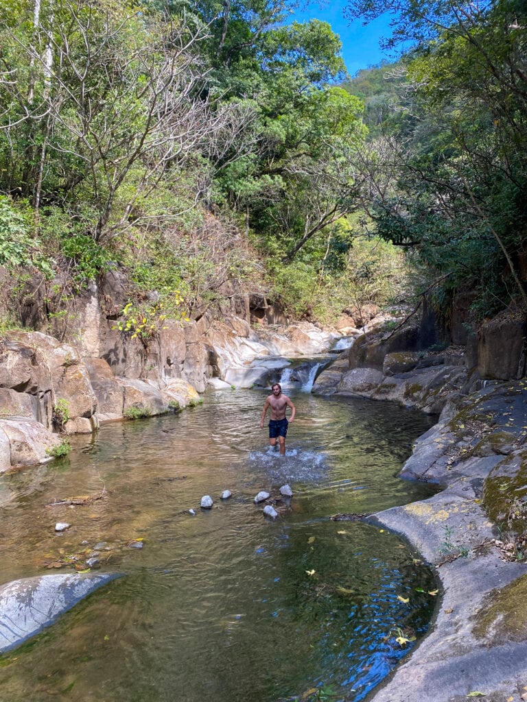 Dan standing in a pool with a small waterfall behind him.