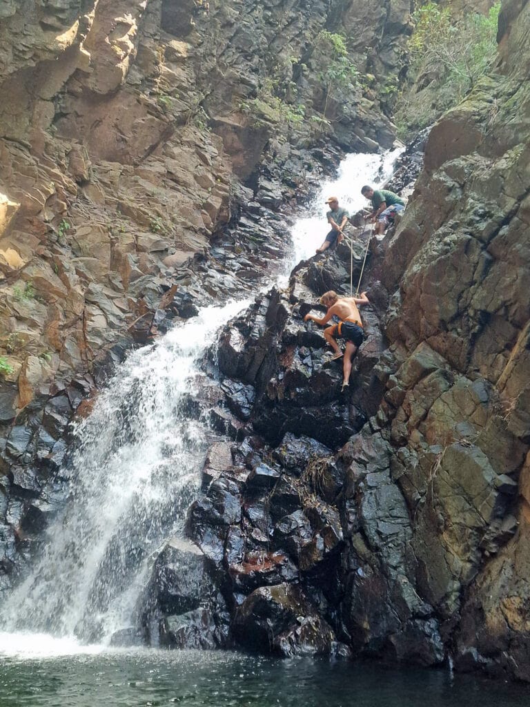 Dan rock climbing down a waterfall.