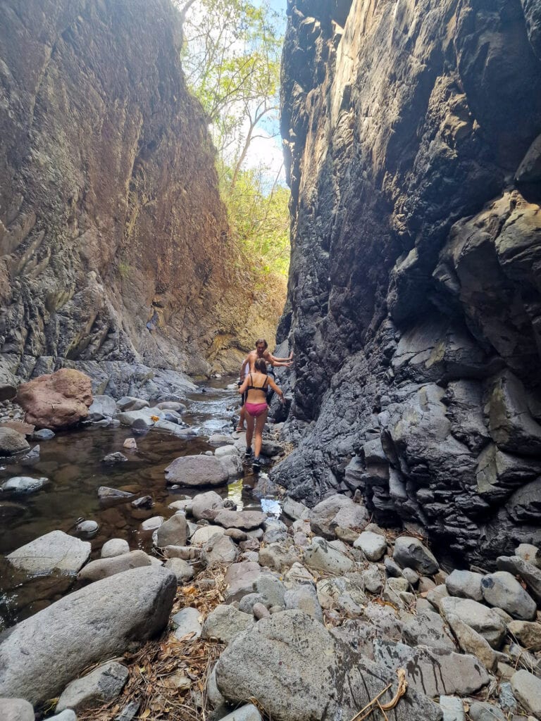 Sarah and Dan hike through a rock canyon.