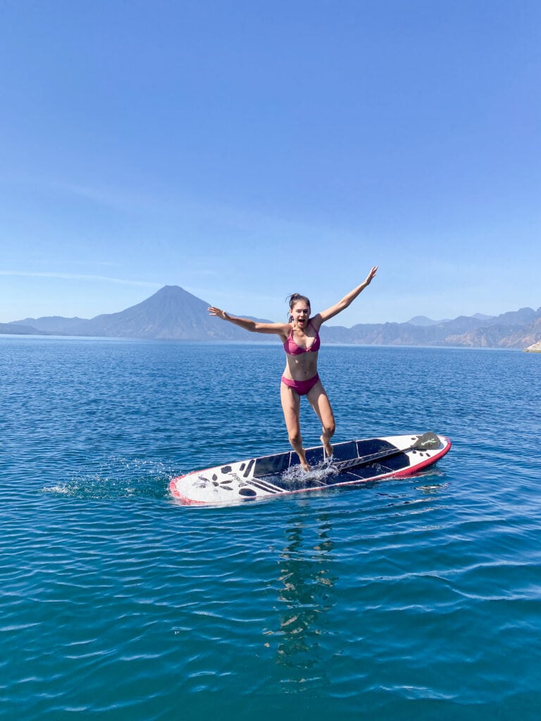 Sarah jumps off her paddle board into Lake Atitlan.