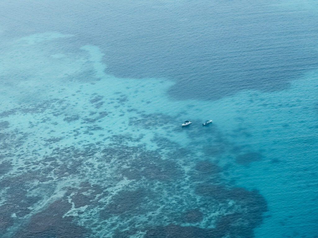 Two boats off the coast of Belize, viewed from the Blue Hole flight