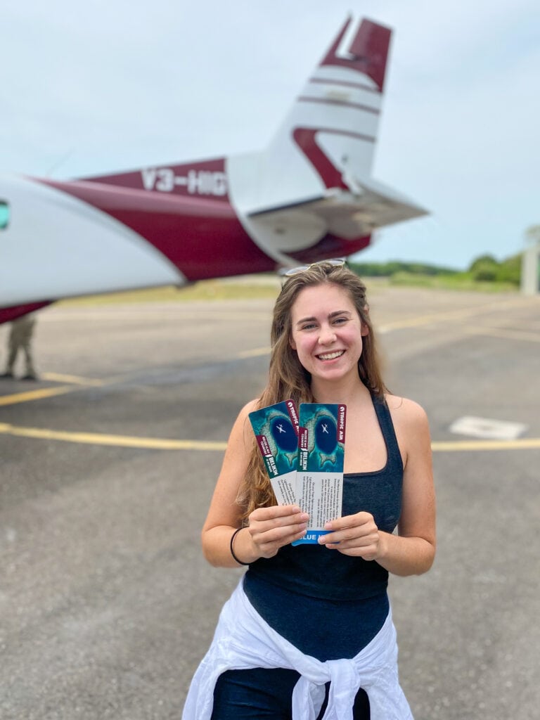 Sarah holds two tickets and smiles